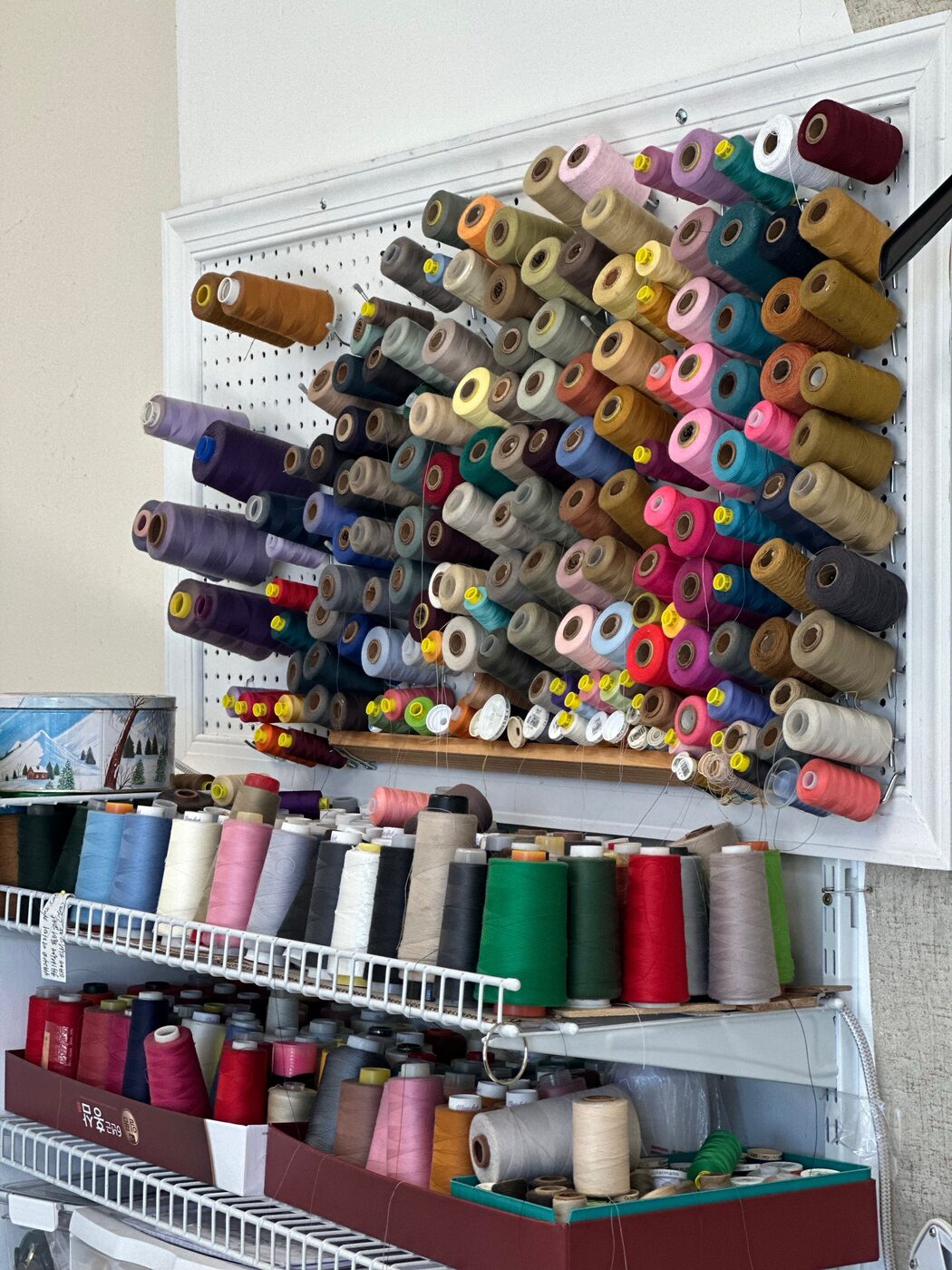 Wall of thread spools used for alterations at KYM Amen